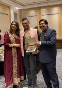 Rohan D'Souza poses for photo with colleagues holding his FOGSI award. 