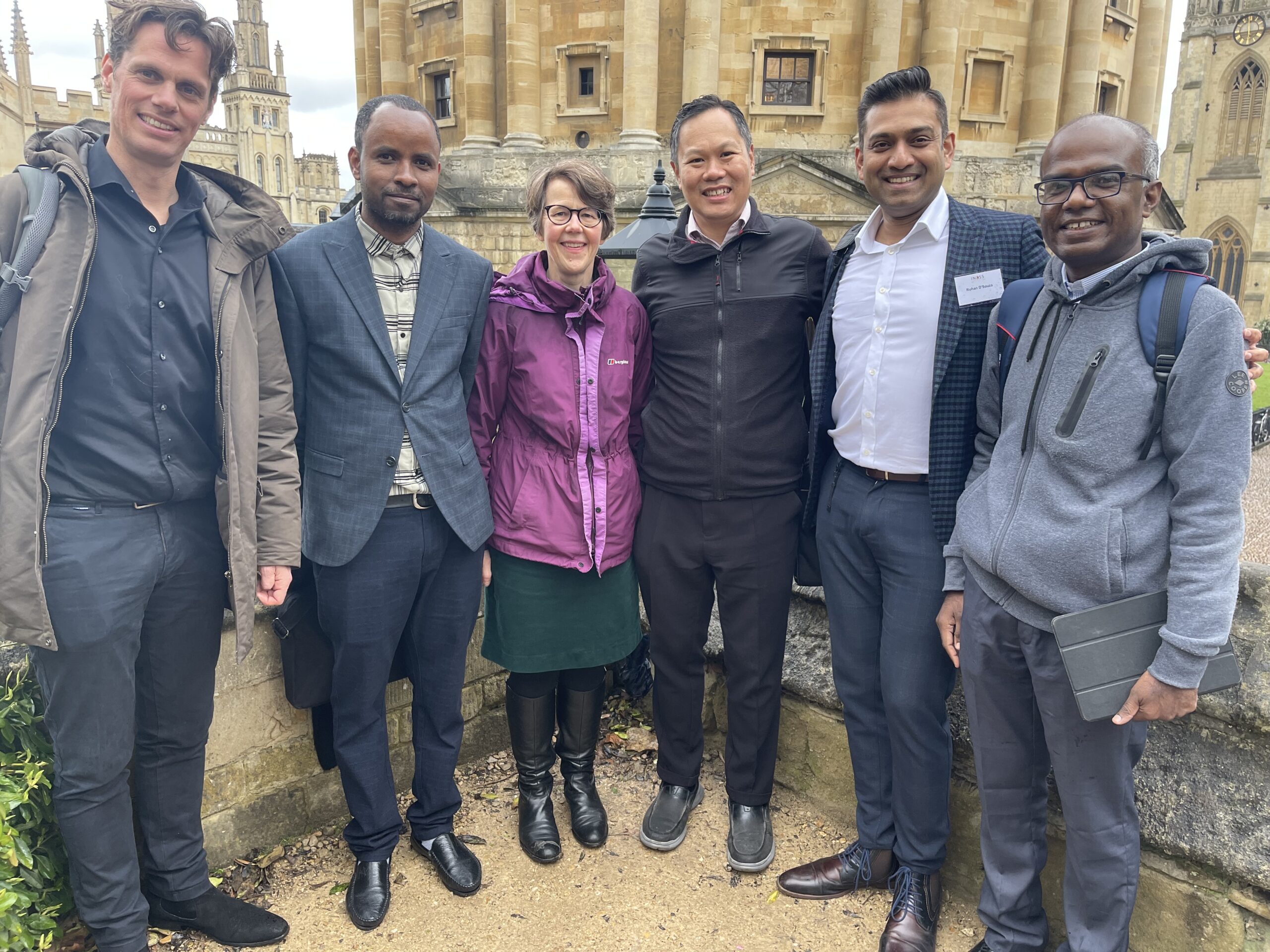 Rohan D'Souza and colleagues stand in front of a building. 